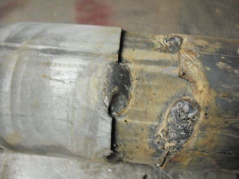 1991 Ford Bronco - Exhaust pipe section showing welds and signs of rust and wear.