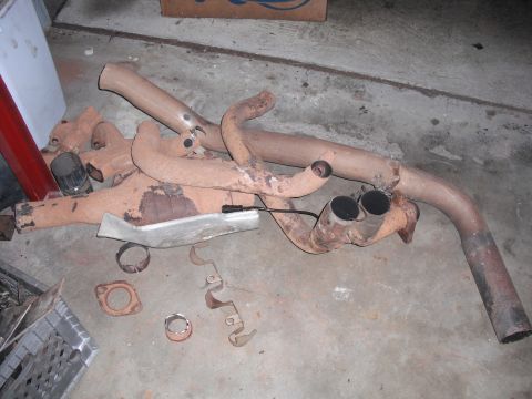 1991 Ford Bronco - This rusty exhaust system features dual tailpipes and appears to be a custom Y-pipe setup.