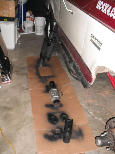 1991 Ford Bronco - Exhaust components for a 1991 Ford Bronco are laid out on cardboard for painting.
