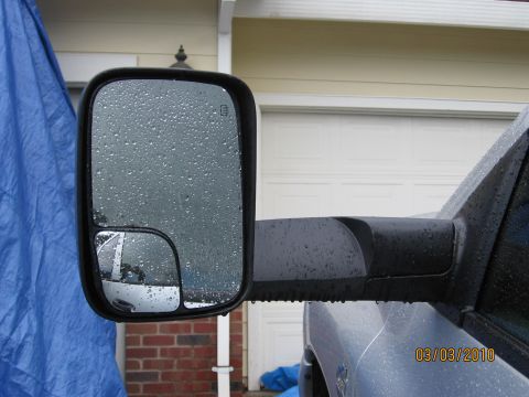 2007 Dodge 2500 - The side mirror of a 2007 Dodge 2500 is covered in raindrops on a cloudy day.