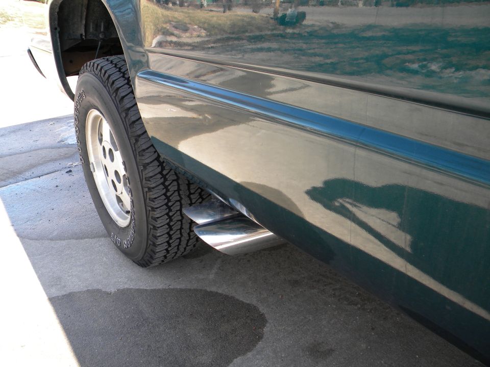 Green truck side view with dual exhaust pipes and chrome trim. 1995 GMC Sierra 1500