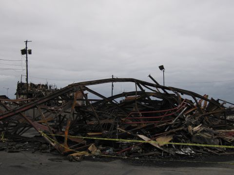 2001 Ford Crown Victoria - Scene of destruction after a fire, with extensive damage to structures and scattered debris.