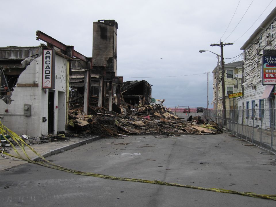 Street scene with fire-damaged buildings and debris, caution tape