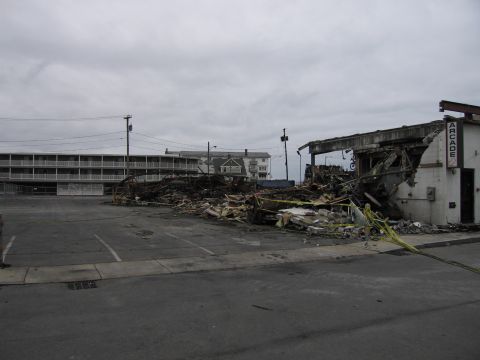 2001 Ford Crown Victoria - The aftermath of a fire shows a collapsed building with debris scattered across the parking lot.