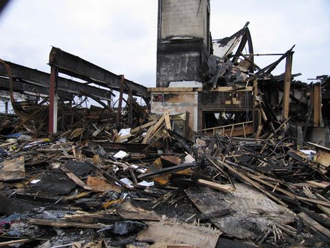 2001 Ford Crown Victoria - Scene of a building destroyed by fire, with extensive structural damage and debris.