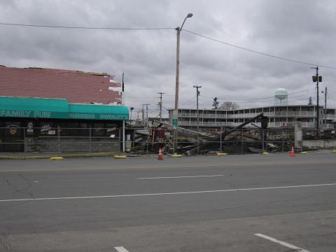 2001 Ford Crown Victoria - The aftermath of a fire shows significant structural damage to a building, with debris scattered across the site.