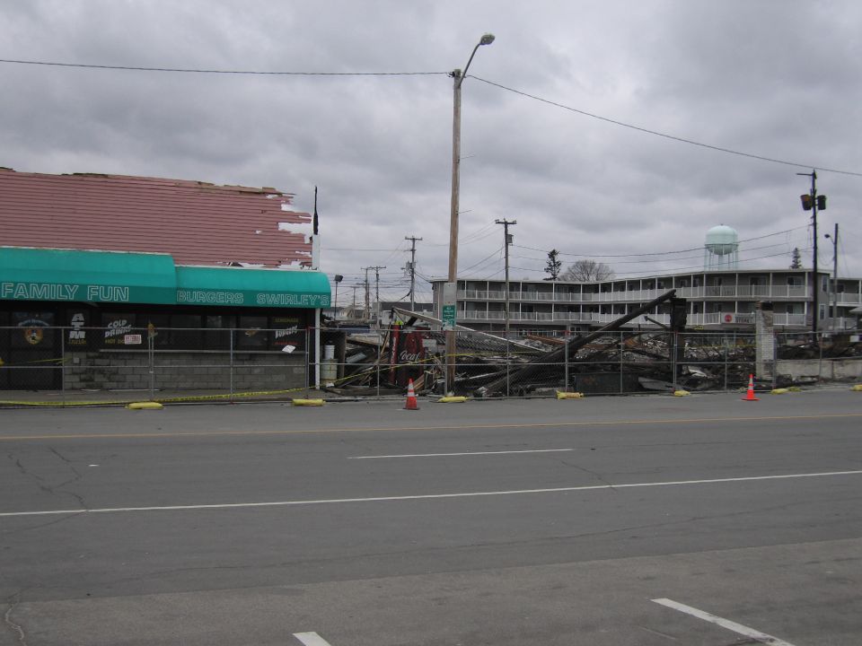Scene of fire damage with a partially collapsed building and debris