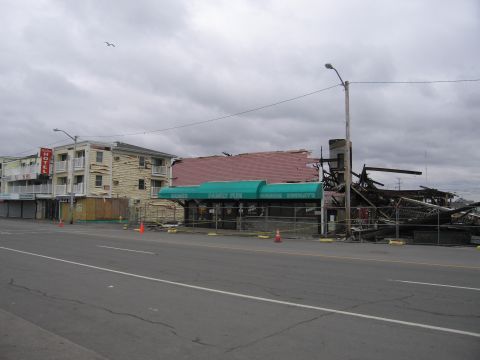2001 Ford Crown Victoria - A street view shows buildings damaged by fire, with one structure partially collapsed and debris scattered.