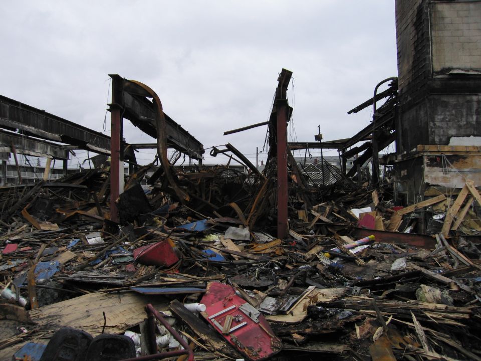 Scene of a building destroyed by fire, with debris and structural damage