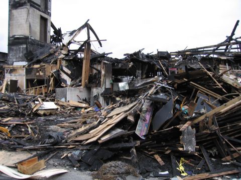 2001 Ford Crown Victoria - Extensive damage to a building following a fire, showing collapsed structures and scattered debris.