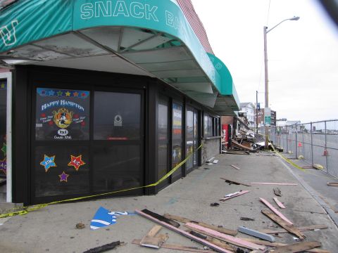 2001 Ford Crown Victoria - A storefront shows damage with debris scattered on the sidewalk and caution tape.