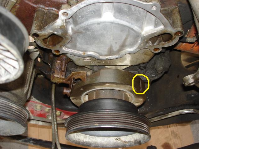 Engine pulley and water pump assembly with yellow circle highlighting a small component