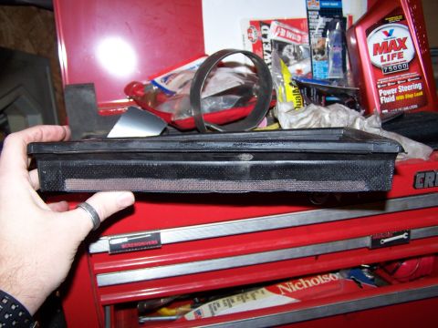 1986 Ford Bronco - A hand holds an air filter above a red toolbox containing automotive parts and fluids.