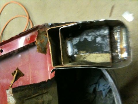 1993 Ford Bronco - Close-up of a heavily rusted and cut vehicle frame section, showing internal metal structures.