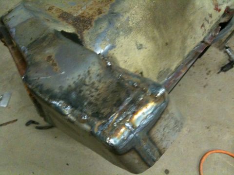 1993 Ford Bronco - A heavily rusted and welded metal component, likely a vehicle part, is shown in a close-up view.