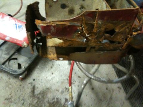 1993 Ford Bronco - This heavily rusted vehicle frame section displays extensive corrosion and structural damage.