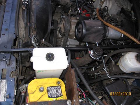 1994 Ford Bronco - Close-up view of an engine bay an aftermarket air filter and a yellow battery, with a date stamp of 03/03/2010.