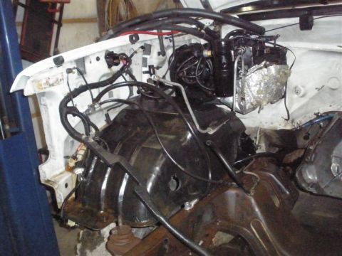 1994 Ford F-350 - The engine bay of a truck shows the area where the engine was removed, revealing the frame and various hoses.