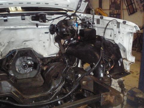 1994 Ford F-350 - Engine bay of a 1994 Ford F-350 with the engine removed, revealing the transmission and brake system.