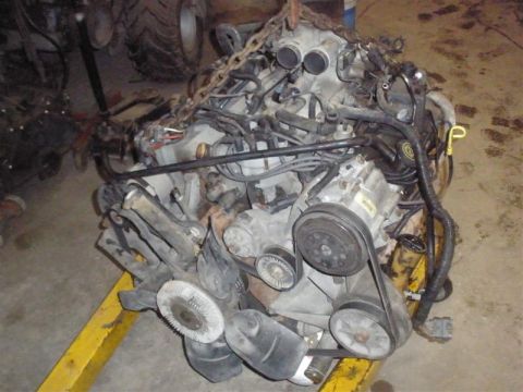 1994 Ford F-350 - This V8 engine is out of a vehicle and is being worked on. It is suspended by chains.