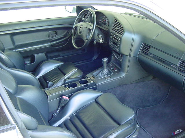 Black leather interior of a BMW E36 with manual shifter and sport seats