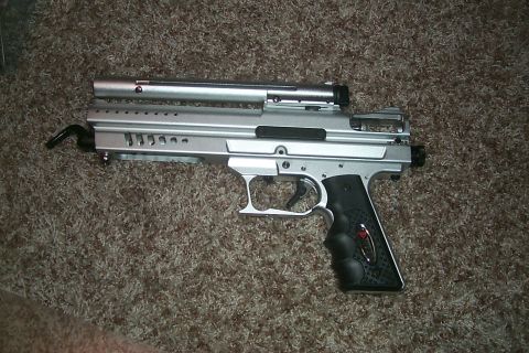 1986 Ford Bronco - A silver paintball gun with a black grip rests on a carpeted surface.