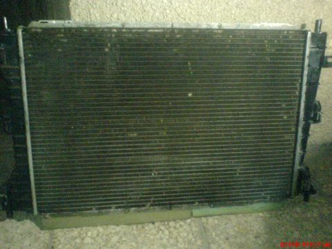 1998 Ford Crown Victoria - A dirty radiator, likely from a vehicle, is shown in a close-up view.