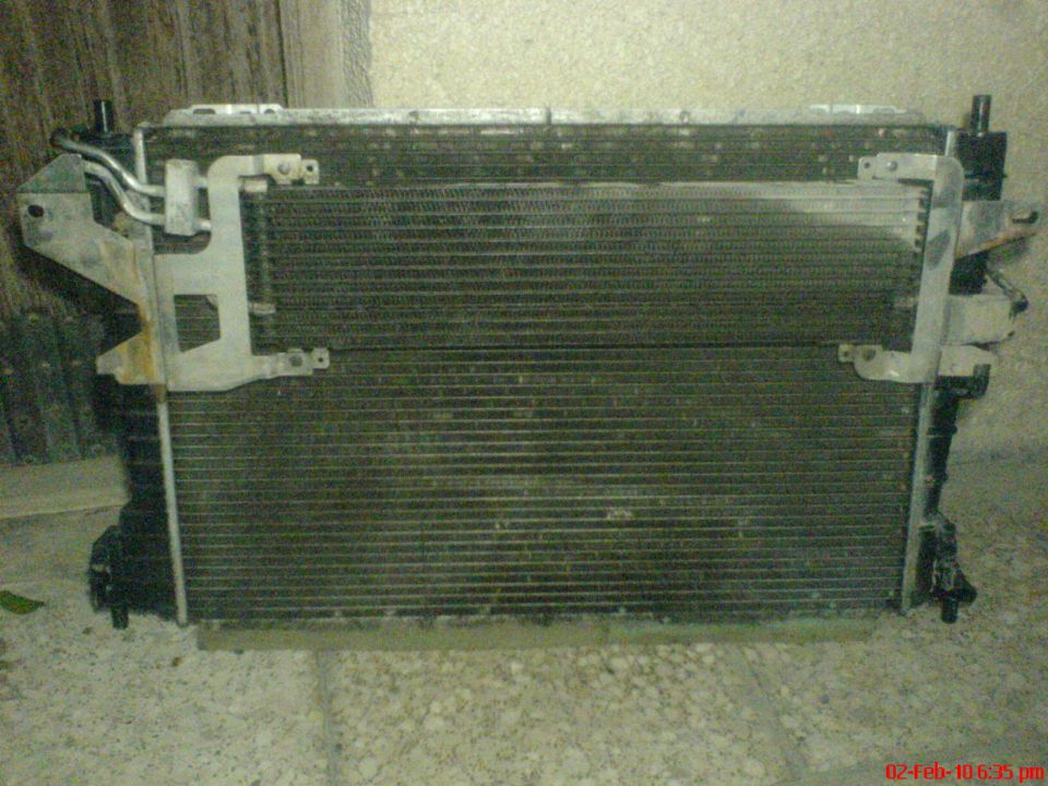 Radiator and AC condenser assembly with metal mounting brackets
