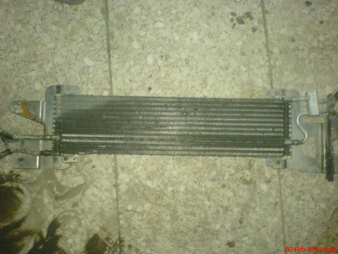 1998 Ford Crown Victoria - A radiator part is shown lying on a concrete surface, possibly for repair or replacement.