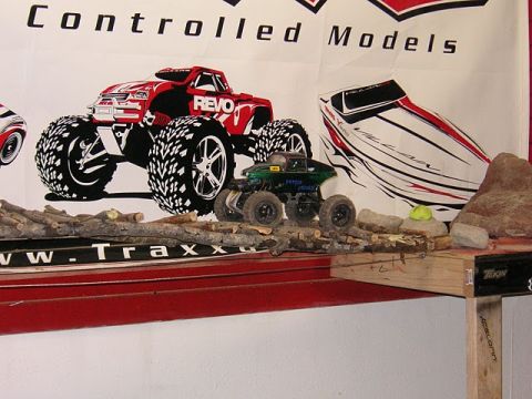 1993 Suzuki Sidekick - RC monster trucks and a boat graphic are displayed on a shelf with a wooden track.