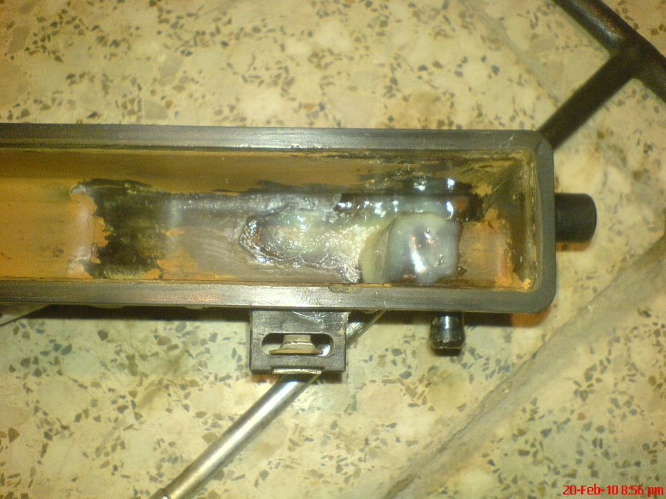 Rusted metal part with white residue and visible corrosion