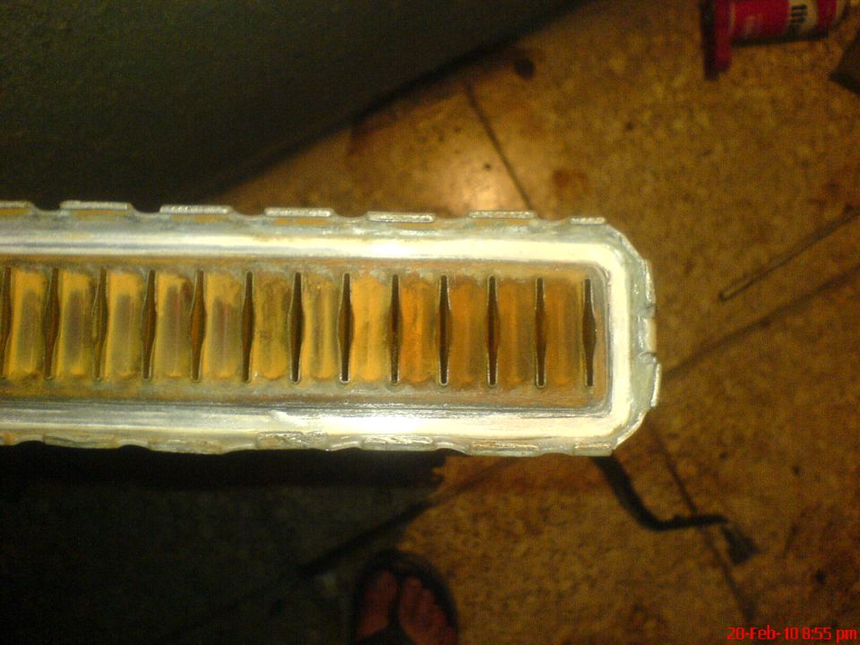 Close-up of a radiator core with visible corrosion and debris in the fins