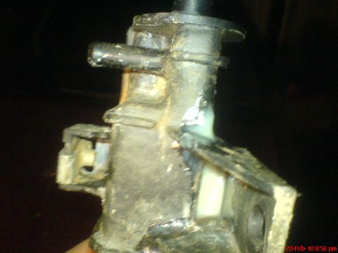1998 Ford Crown Victoria - This image shows a close-up of a dirty automotive part, likely a component from a vehicle's cooling system.