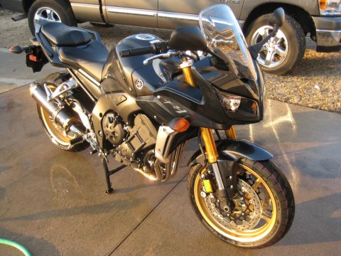 2008 Yamaha FZR1000 - A black Yamaha FZ1 motorcycle is parked on a concrete surface, with a pickup truck in the background.