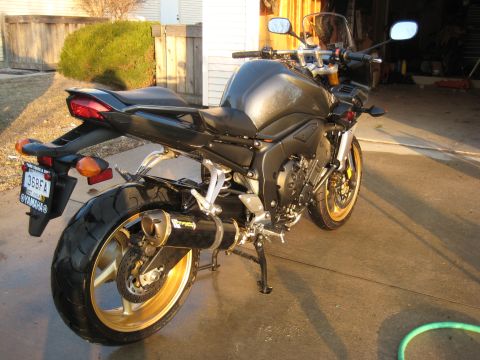 2008 Yamaha FZR1000 - This motorcycle features gold wheels and an aftermarket exhaust system, seen from the rear.
