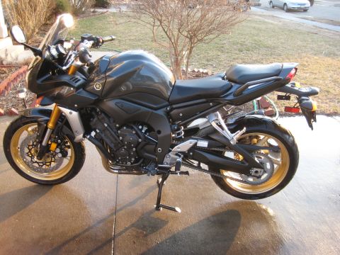 2008 Yamaha FZR1000 - Side view of a 2008 Yamaha FZR1000 motorcycle parked on a wet concrete surface.