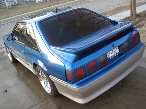 1990 Ford Mustang - The rear view of a blue coupe shows its distinctive taillights and spoiler.