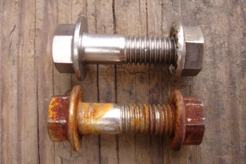 1995 Ford Taurus - Comparison of a new bolt and a rusty bolt, likely for automotive use.