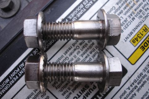 1995 Ford Taurus - Two bolts are shown resting on a document that appears to be an owner's manual or service information.