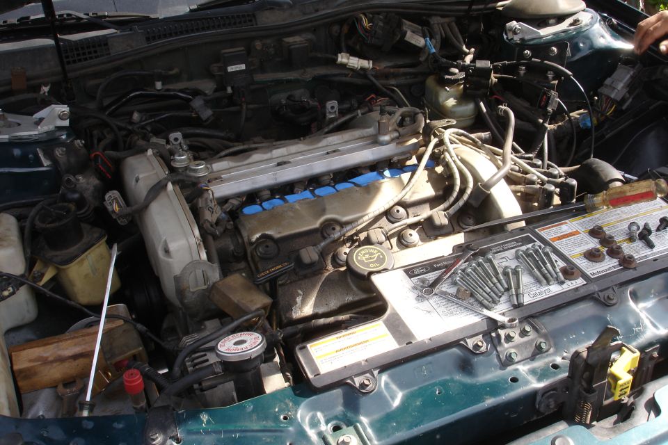 1995 Ford Taurus engine bay with cam seals and bolts laid out