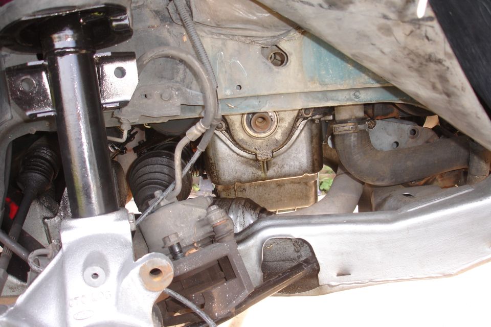 Engine oil pan and suspension components of a vehicle