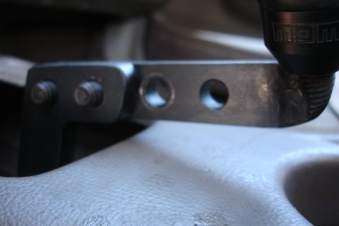 1995 Ford Taurus - Close-up of a MOMO shift knob and metal short shifter mechanism with adjustment holes.