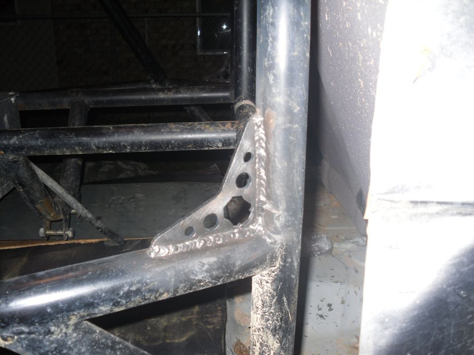 Close-up of welded metal bracket connecting roll cage tubes