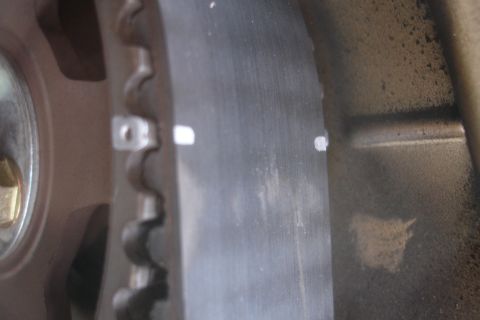 1995 Ford Taurus - A close-up view of a vehicle's timing belt and a pulley, showing alignment marks.