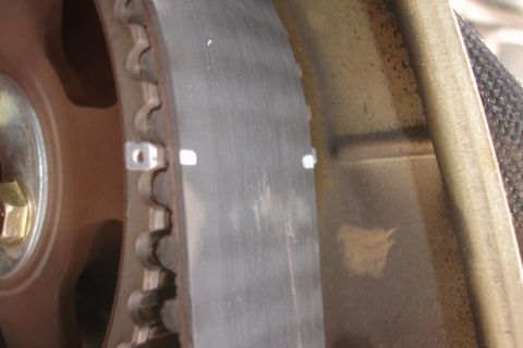 1995 Ford Taurus - A close-up view of a vehicle's timing belt and pulley system, showing white alignment marks on the belt.