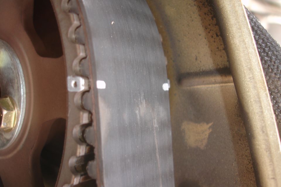 Close-up of a timing belt with white marks and a toothed pulley