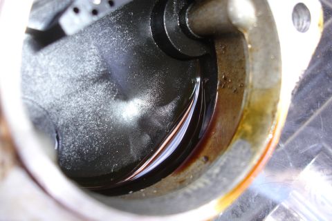 1995 Ford Taurus - This is a close-up view of an engine component, likely a seal housing, showing oil and debris.