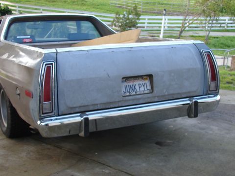 1973 Ford Ranchero - The rear of a light blue Ford Ranchero pickup truck is shown with a custom license plate reading 'JUNK PYL'.