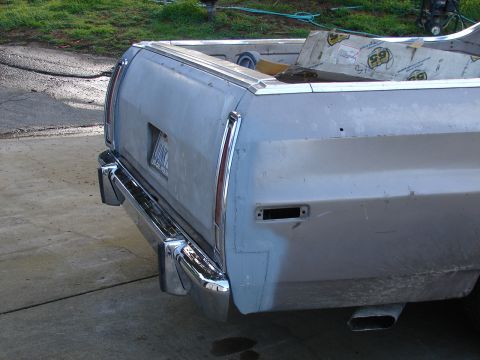 1973 Ford Ranchero - The rear of a 1973 Ford Ranchero shows its chrome bumper and a tailgate that appears to be in need of repair.