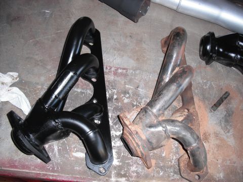 1991 Ford Bronco - Comparison of a new black exhaust manifold next to an old rusty one.